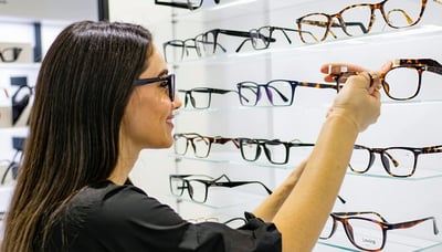 Optometrist helping a customer select eyeglass frames at Loving eyez